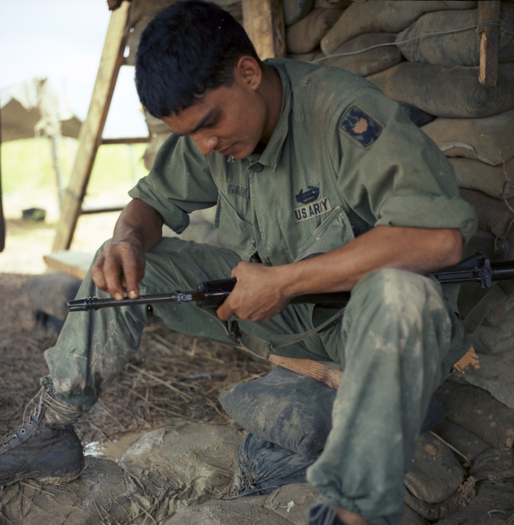 "Operation Shelby - Pfc Manuel Garcia (El Centro, Calif.) rifleman...cleans his M-16 rifle..." 8/25-26/1967