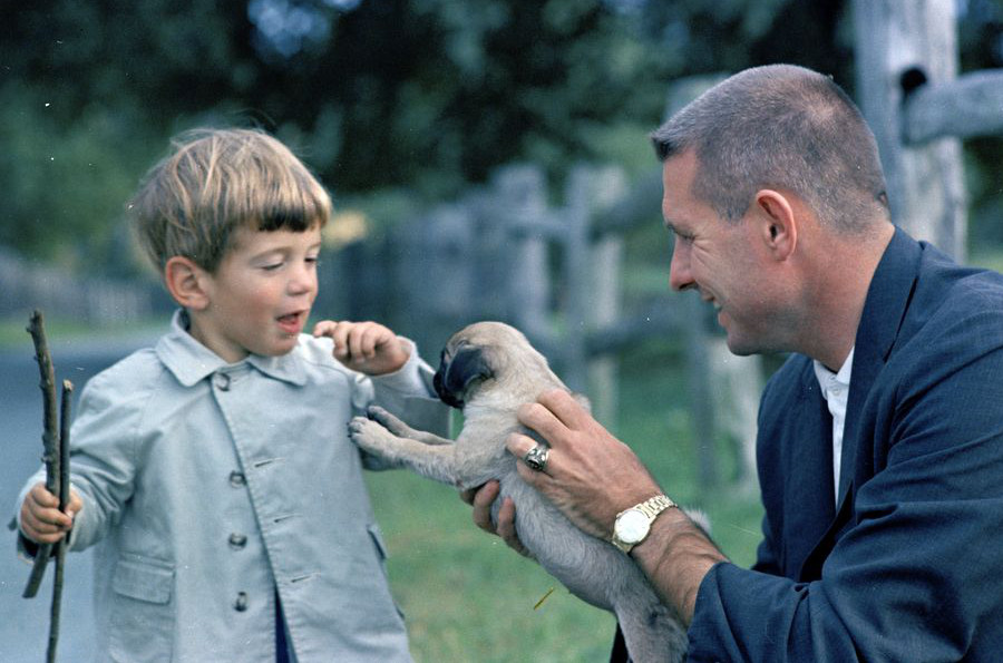 JFK Jr. plays with a dog on the farm